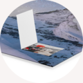 En öppen CEWE fotoalbum på en blå bakgrund, med ett foto synligt.